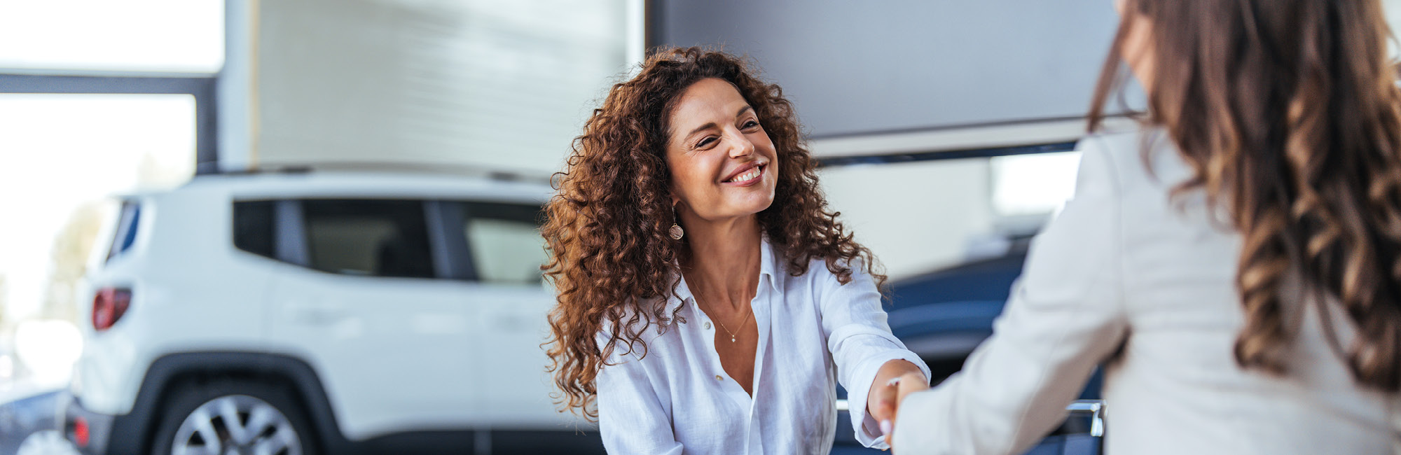 Glückliche Kundin und Beraterin geben sich die Hand